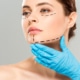 plastic surgeon touching face of attractive woman with marked face