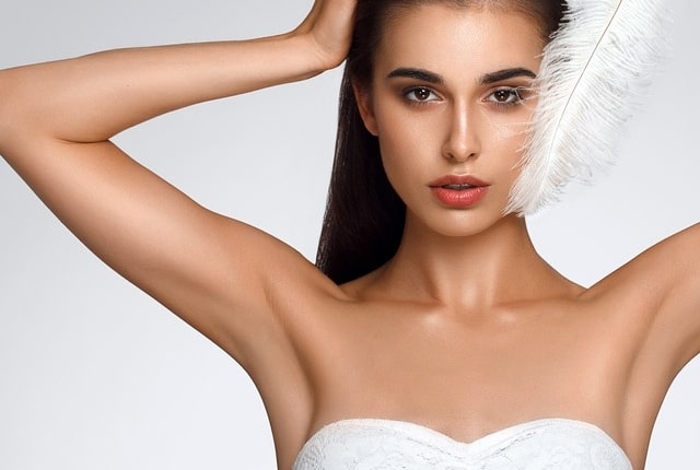 woman holding her arms up and showing clean underarms
