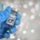 Blue-gloved hand holding a vial with a male symbol, representing hormone injections and steroid use concept