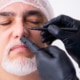 Older man consulting with a male doctor about plastic surgery for a nose job, discussing rhinoplasty options and facial aesthetics.