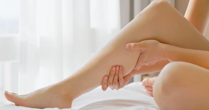 Close-up of hands massaging calf implants to support healing and improve results after calf augmentation surgery