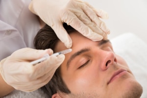 Man receiving Botox injection for wrinkle smoothing and facial rejuvenation at cosmetic clinic