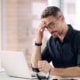 Man experiencing fatigue and trouble focusing at work due to low testosterone.